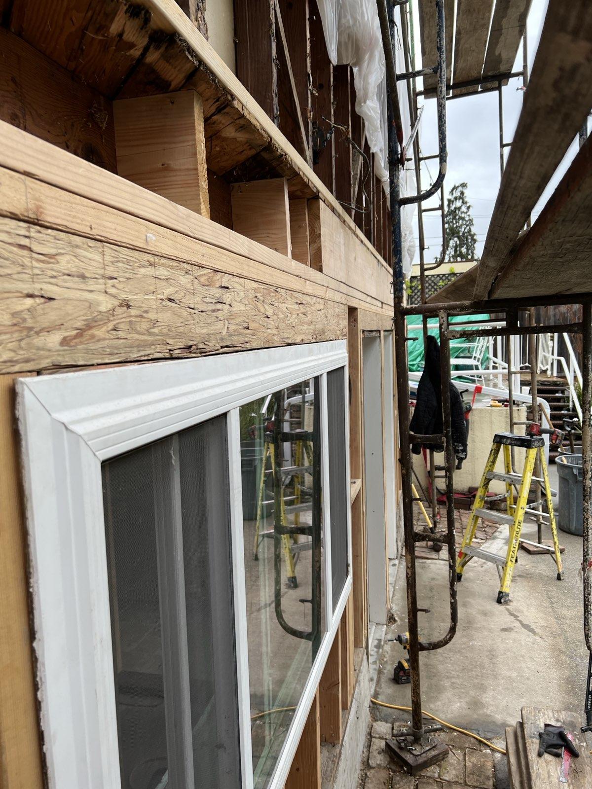 New sister-joist framing installed and new dual-pane window in place — clean carpentry detail ready for sheathing and stucco closure