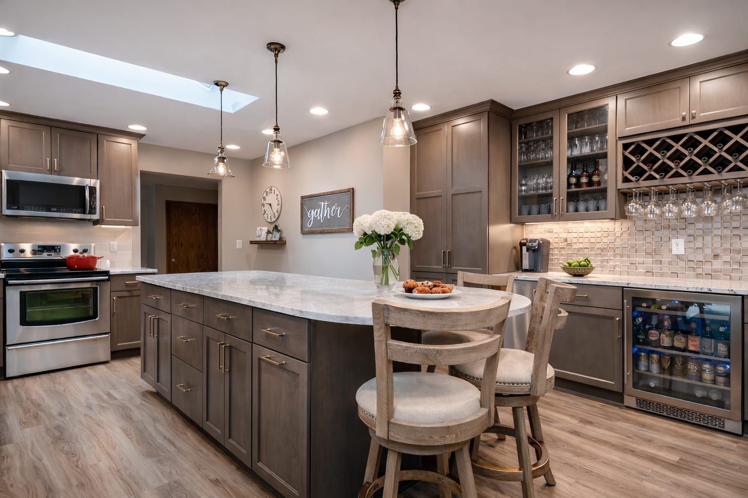 Fully remodeled Bay Area kitchen with marble island, shaker cabinetry, pendant lighting, wine bar, and skylight by Gadget Construction